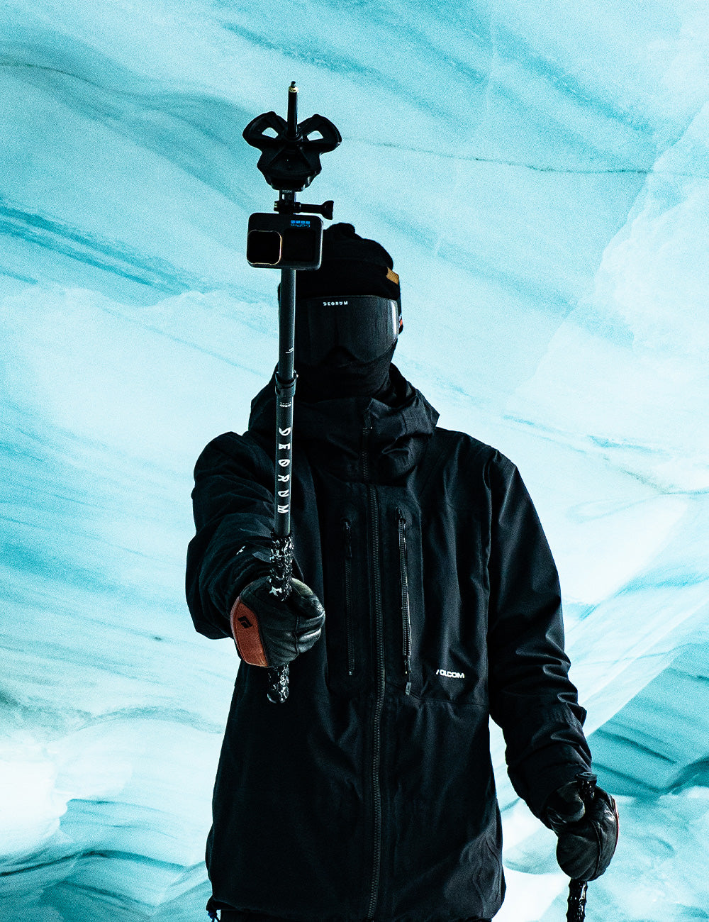 A skier holding a ski pole with a GoPro mount